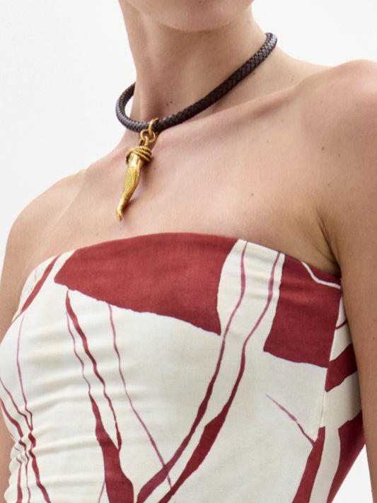 The Dominica Chocker is a brown leather choker featuring a gold clasp and an ornate cornicello pendant, crafted from fine Italian materials and elegantly showcased at the center.