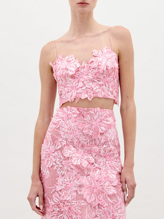 A person wearing the Alida Top and The Astrid Skirt in color Pink on a white background.