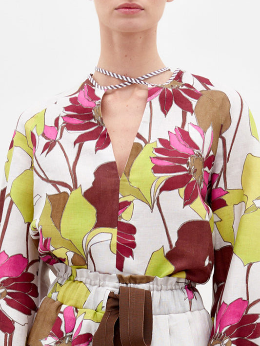 A person stands against a plain background wearing the Molveno Blouse.